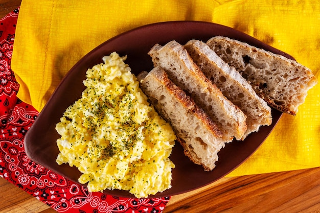 Foto huevos revueltos y rebanadas de pan artesanal