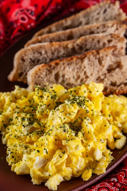 Foto huevos revueltos y rebanadas de pan artesanal