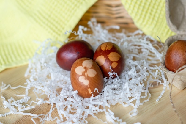 Huevos rojos pintados cocinados para Pascua yacen en dibujos de papel cortado en huevos de Pascua