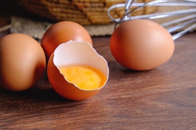 Huevos rotos durante la puesta de huevos sobre la mesa.