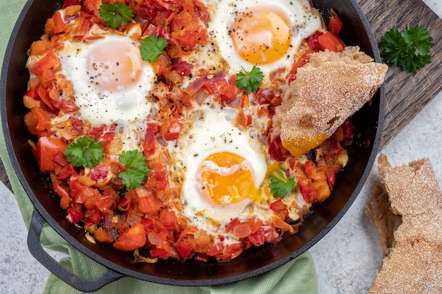 Huevos Shakshouka escalfados en salsa de tomates pimientos y cebolla Comida cetogénica baja en carbohidratos