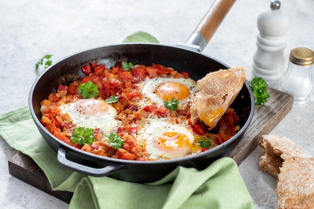 Huevos Shakshouka escalfados en salsa de tomates