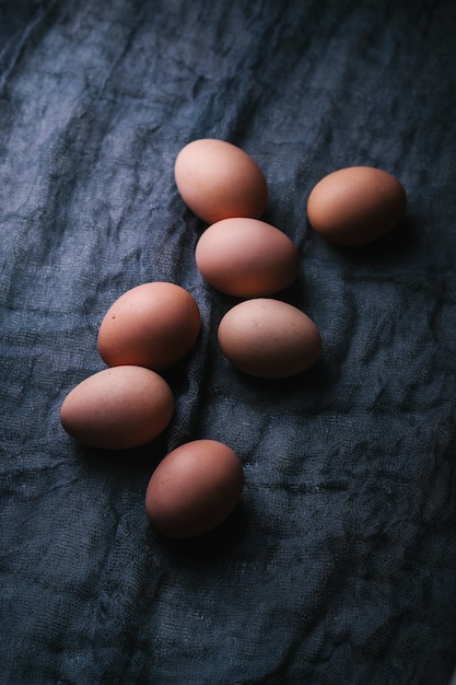 Huevos sobre tela oscura. Concepto de comida ecológica.