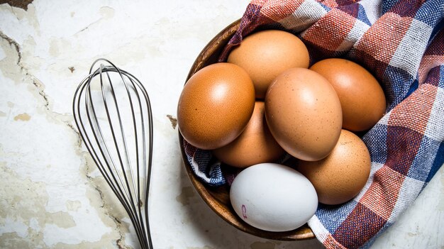 Huevos en una taza con un paño y batir