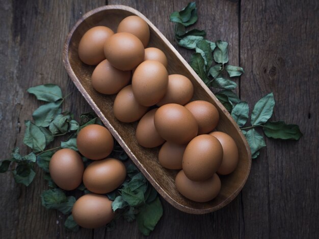 huevos en un tazón de madera en la mesa de los viejos tableros