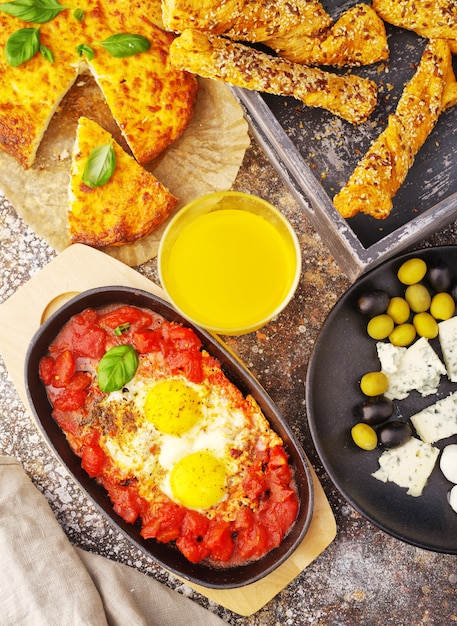 huevos con tomate, queso, aceitunas, jugo de naranja y pan