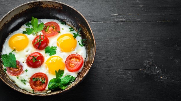 Huevos con tomates y verduras en una sartén