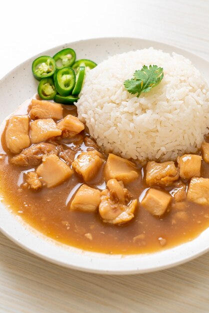 Huhn in brauner Sauce oder Soße mit Reis - asiatische Art zu essen