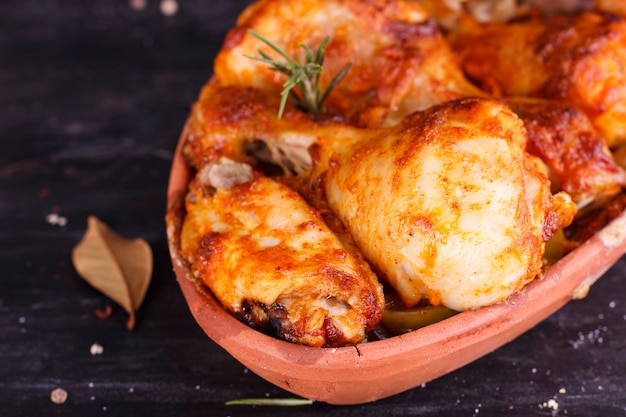 Huhn in Paprikasoße im Ofen in der Keramik gebacken. Hühnerbeine und Flügel