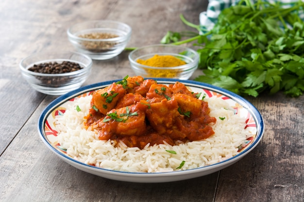 Huhn Tikka Masala mit Reis auf Holztisch