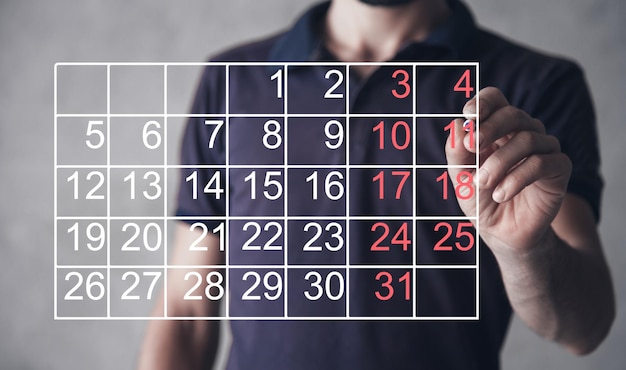 Humano mostrando calendário com números pretos e vermelhos