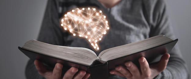 Foto humano mostrando o livro com um cérebro humano knowledge education