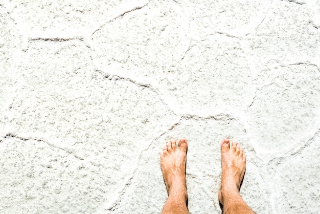 Humano nu descalço no fundo da superfície salgada em excursão turística em Salar de Uyuni, perto da Ilha Incahuasi - Conceito de estilo de vida de liberdade e desejo por viagens despreocupado viajando ao redor do mundo - Filtro ensolarado