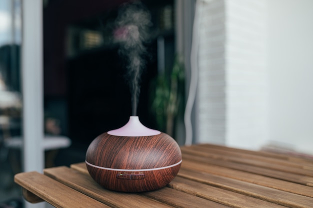 Humidificador inteligente contemporáneo sobre mesa que emite vapor de agua