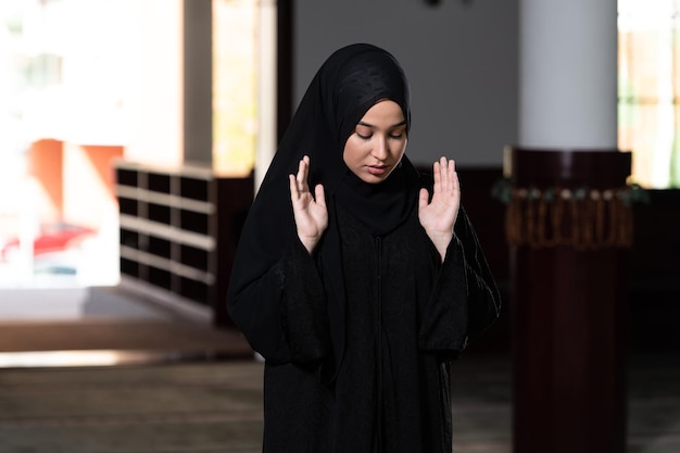 Humilde mujer musulmana está rezando en la mezquita
