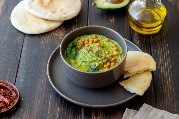 Hummus de aguacate en un tazón gris. Alimentación saludable. Comida vegetariana.