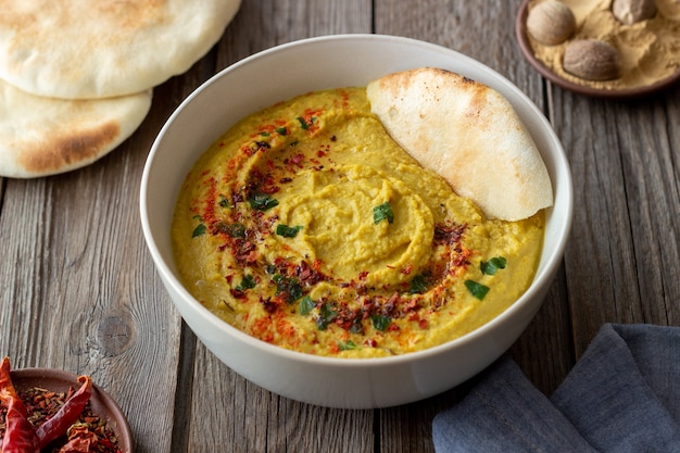 Hummus con condimentos y pita. Alimentación saludable. Comida vegetariana. Dieta.