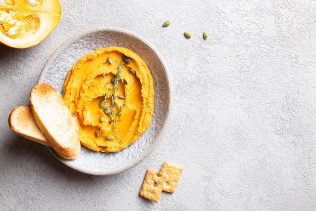 Hummus de abóbora decorado com verduras e pão torrado