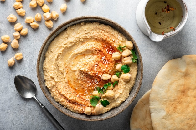 Hummus em uma tigela de cerâmica em uma vista superior de fundo claro