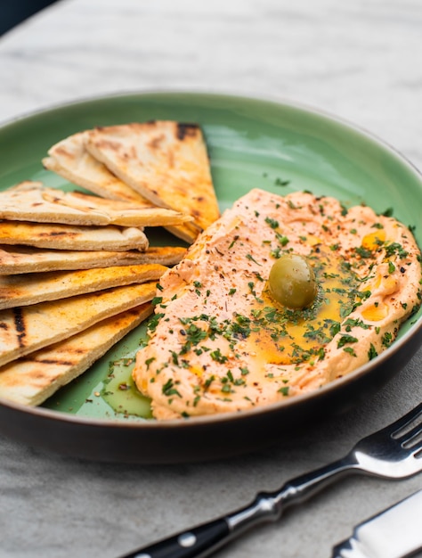 Hummus con hierbas picantes aceite de oliva y tortas comida tradicional oriental