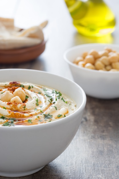 Hummus in der Schüssel auf einem rustikalen Holztisch