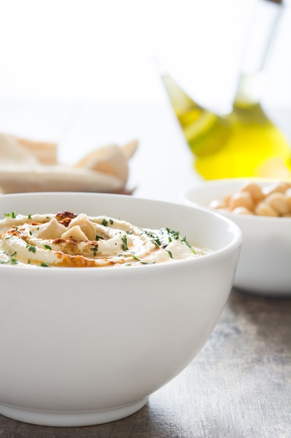 Hummus in der Schüssel auf einem rustikalen Holztisch