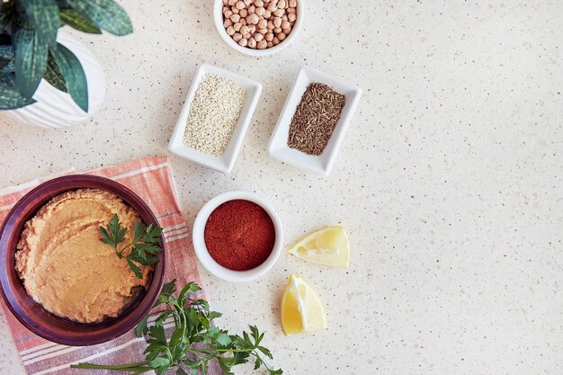 Hummus mit Kichererbsen und Tahini-Sauce in der Schüssel, Petersilie, Zitrone, Paprika, Römerkümmel, Kichererbse