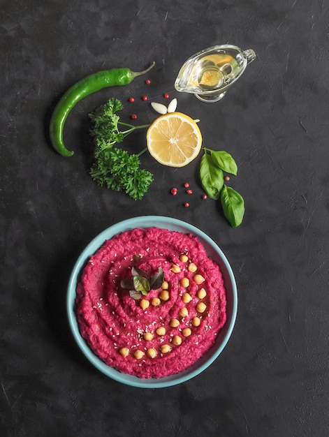 Hummus mit Rote Beete auf einem schwarzen Küchentisch