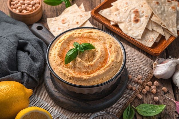 Foto hummus oriental con sésamo, limón y ajo en el fondo de los ingredientes