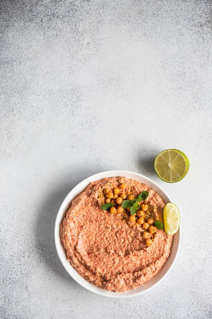 Hummus de pimiento rojo asado adornado con menta y lima