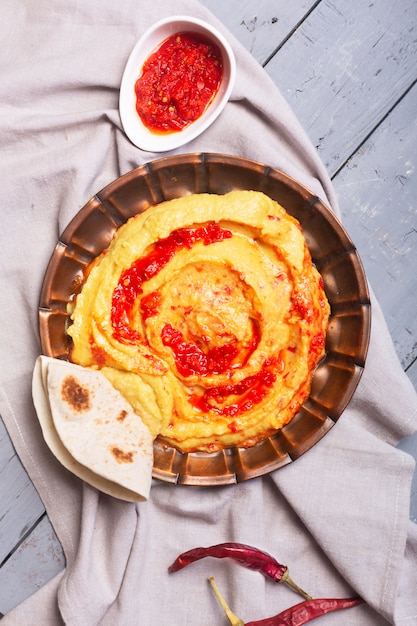 Hummus en un plato. Plato de garbanzos preparado con salsa harissa