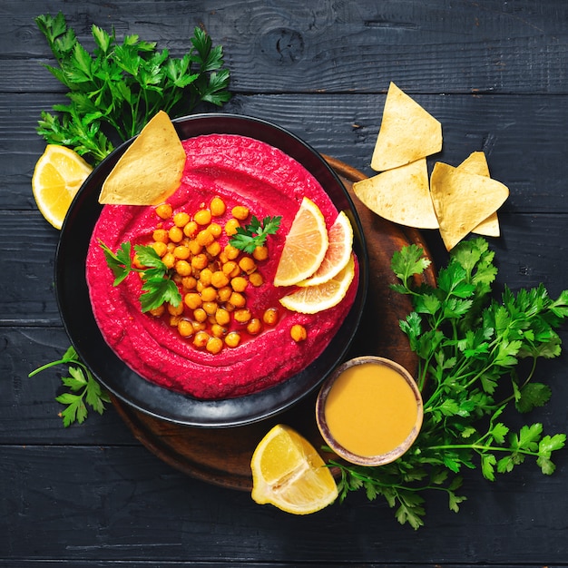 Hummus de remolacha fresca en placa con garbanzos y vista superior de pan de pita Concepto de comida vegana saludable
