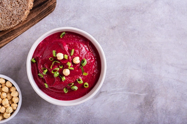 Hummus de remolacha en un tazón de pan y garbanzos en la vista superior de la mesa