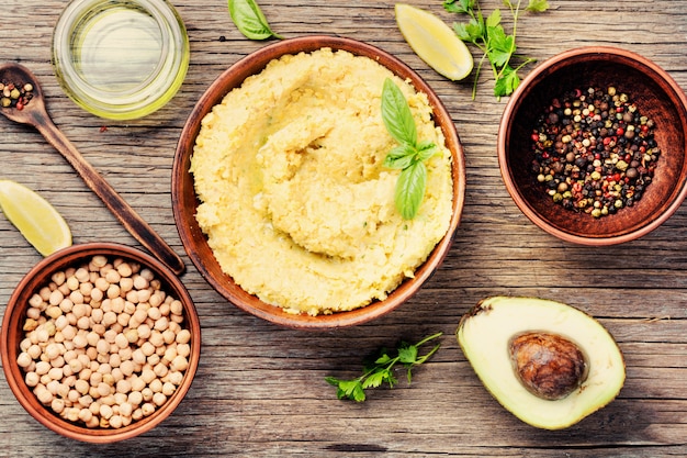 Hummus sobre mesa de madera rústica.