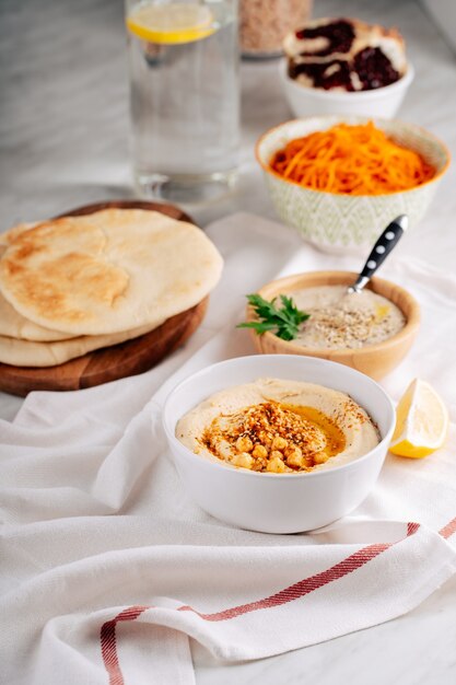 Hummus und Baba Ghanoush in einer Schüssel und Fladenbrot auf einem hellen Hintergrund.