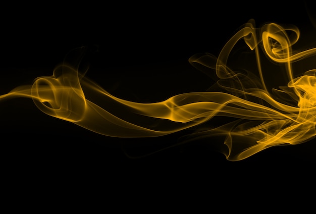 Humo amarillo abstracto en fondo negro. diseño de fuego