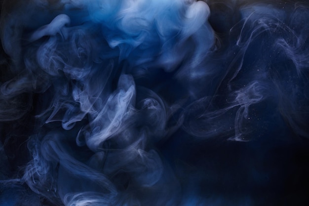 Humo azul sobre fondo de tinta negra, niebla colorida, mar abstracto remolino, pigmento de pintura acrílica bajo el agua