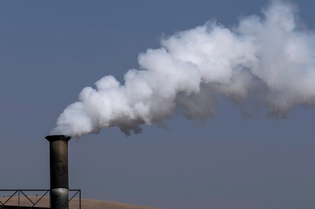 Humo blanco que sale de la chimenea de la fábrica