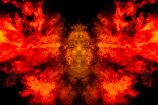 Humo de diferentes colores naranja y rojo en forma de horror en forma de cabeza, cara y ojo con alas sobre un fondo negro aislado Alma y fantasma en símbolo místico