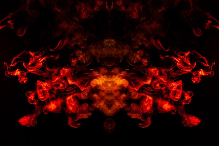 Humo de diferentes colores naranja y rojo en forma de horror en forma de cabeza, cara y ojo con alas sobre un fondo negro aislado Alma y fantasma en símbolo místico