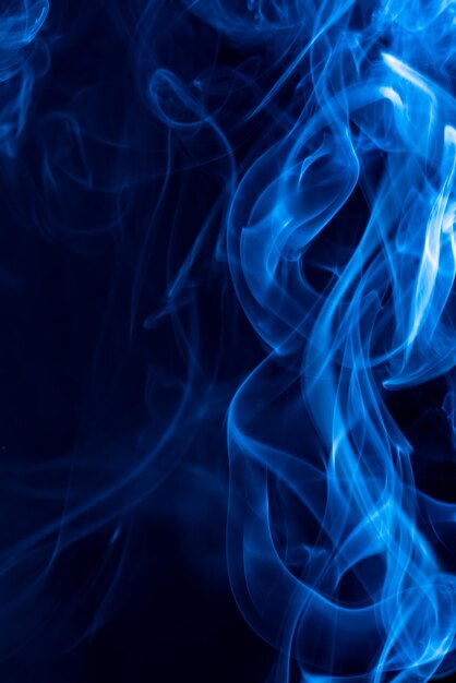 Humo de forma abstracta azul contra un fondo negro