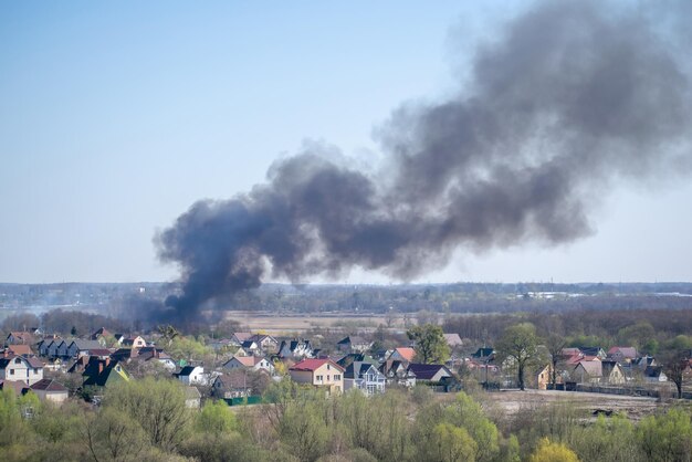 Humo negro del fuego que se eleva por encima de las casas residenciales de un piso