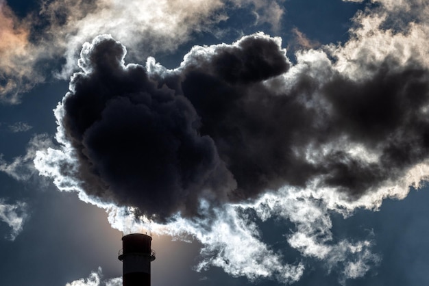 Foto humo oscuro de la chimenea contra el cielo