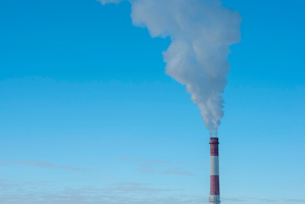 Foto el humo que emite de la chimenea contra el cielo azul