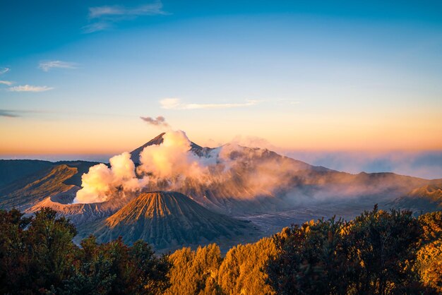 Foto el humo que emite una montaña volcánica contra el cielo