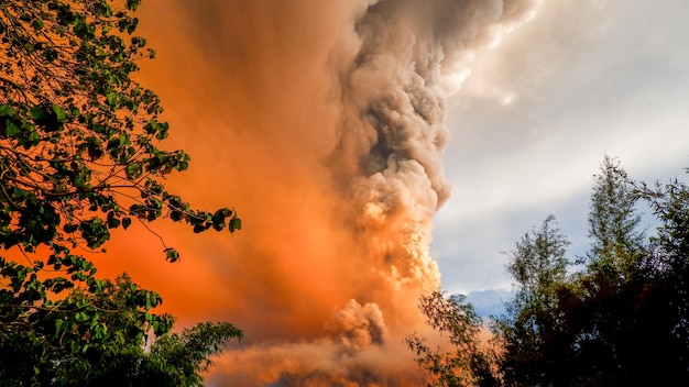 Foto el humo que emite una montaña volcánica contra el cielo