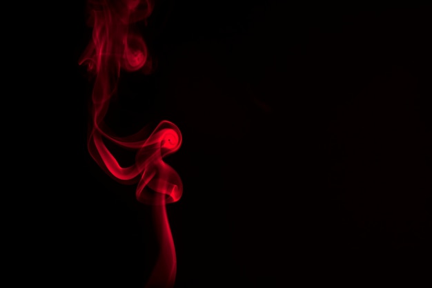 Humo rojo sobre un fondo negro.