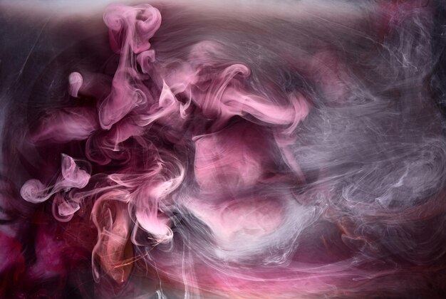 Foto humo rosa sobre fondo de tinta negra, niebla colorida, abstracto remolino toque mar océano, pigmento de pintura acrílica bajo el agua