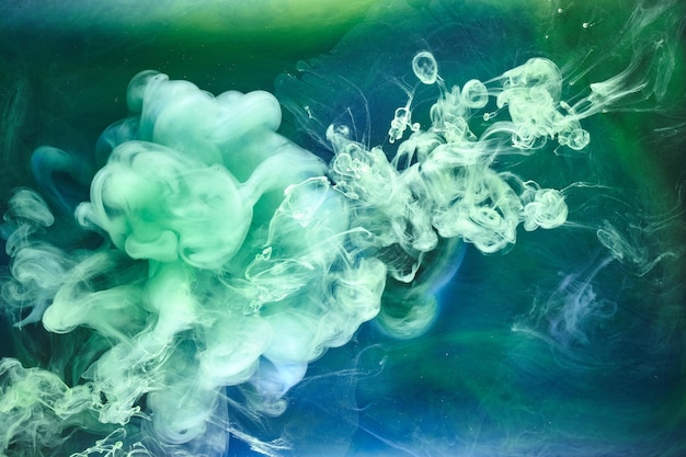 Humo verde azul sobre fondo de tinta negra, niebla colorida, mar abstracto remolino, pigmento de pintura acrílica bajo el agua