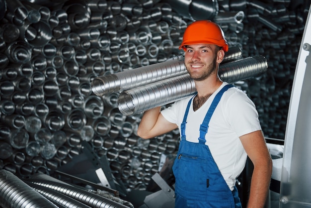 Humor alegre. Homem de uniforme trabalha na produção. Tecnologia industrial moderna.